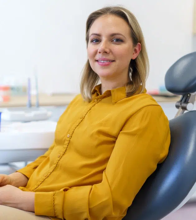 Woman in yellow shirt sitting in dental chair at Calistoga dental office